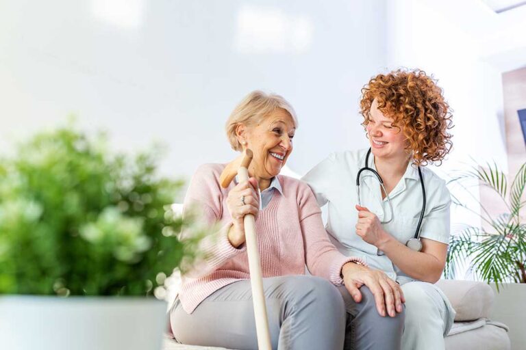 Residents participating in a group activity in a well-lit assisted living common room with comfortable seating.